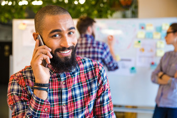 Wall Mural - Afro american man talking on the phone in office