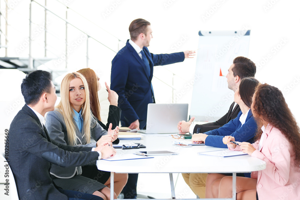 Young businessman making a presentation on a board in the office