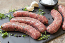 Raw Sausages On Slate With Herbs And  Spices