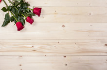 Three Red Roses On A Wooden Board