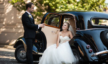 Gorgeous Stylish Blonde Bride Posing In Retro Black Car With Gro