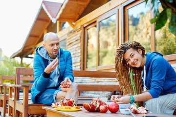 young couple in the garden eating pomegranates