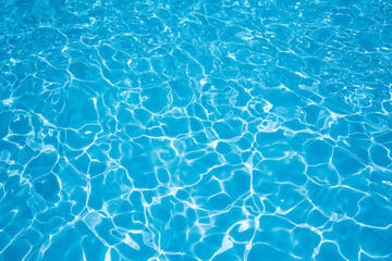 water in swimming pool with sun reflection