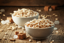 Puffed Sweet Rice In Caramel In White Porcelain Bowls With Cane