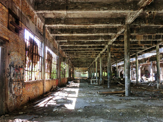  Crumbling abandoned factory warehouse with broken windows, landscape photo