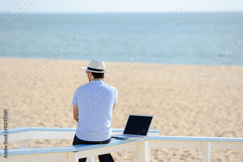 Fotografie, Obraz Businessman working with laptop computer on the beach