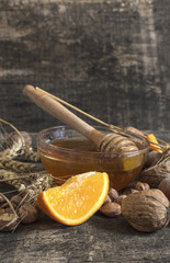 Honey, nuts, wheat and orange fruit on an old vintage planked wo