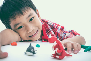 Child show his works from clay, on white. Strengthen the imagination of child