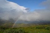 Fototapeta Tęcza - Clouds, rainbow and sunshine over valley in subarctic mountains, Swedish Lapland