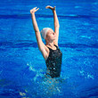 Synchronized swimmer propelling out of the water