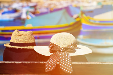 two hats with traditional maltese boats on background