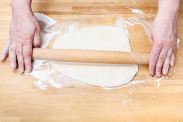 Wall Mural - female hands roll out dough with rolling pin