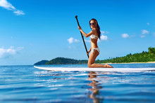 Recreational Water Sports. Healthy Happy Fit Woman With Sexy Body Paddling, Kneeling On Stand Up Paddle, Surf Board In Sea. Summer Holidays Travel Vacation. Active Lifestyle. Leisure Activity. Hobby