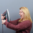 Portrait of woman shouting at iron and tired of house work again