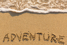 Adventure - Inscription On Sand Beach With The Soft Wave.