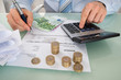 © Andrey Popov - Businessman Calculating Invoice With Money At Desk