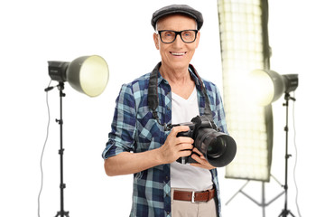 Poster - Senior photographer standing in a studio