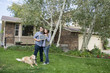 couple and dog in front of new home with sold sign