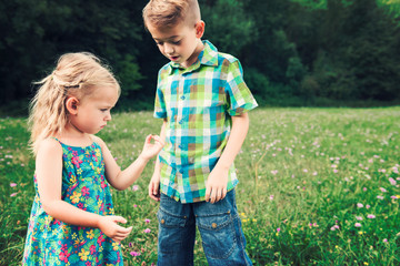 Adorable young girl holding grasshopper, curiosity and education concept