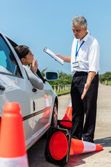 Wall Mural - female learner driver apologising to angry instructor