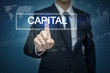 © tonefotografia - Businessman hand touching CAPITAL button on virtual screen