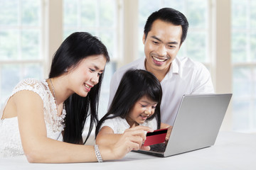 Poster - Child and her parents shopping online at home