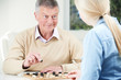 © highwaystarz - Senior Man Playing Checkers With Teenage Daughter