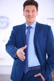 Fototapeta Pomosty - Business and office concept - handsome businessman with open hand ready for handshake