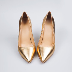 Female gold shoes over white