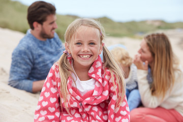 Portrait Of Family Sitting In Sand Dunes Together