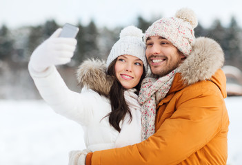 Sticker - happy couple taking selfie by smartphone in winter