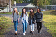 Group Of Young Girls Holding Hands And Laughing While Walking On
