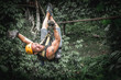 Strong smiling young man zipline in jungle. Adventure zip line extreme entertainment of person flight on rope