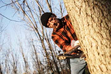 Poster - Senior lumberjack cutting tree with axe in the forest