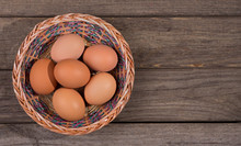 Basket Of Brown Eggs On A Rustic Wooden Background