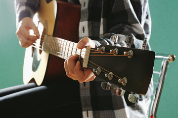 Canvas Print - Musician plays guitar on blue background, close up