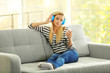 © Africa Studio - Young woman on a sofa listening to music