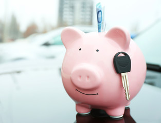 Poster - Piggy money box with cash and key on car bonnet at the street