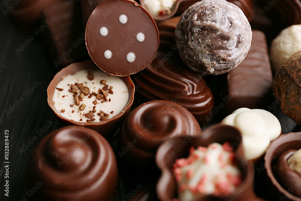 Delicious chocolate candies on wooden background, close up