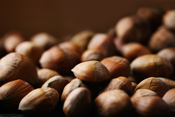 Wall Mural - Scattered hazelnuts and a metal bucket, close-up