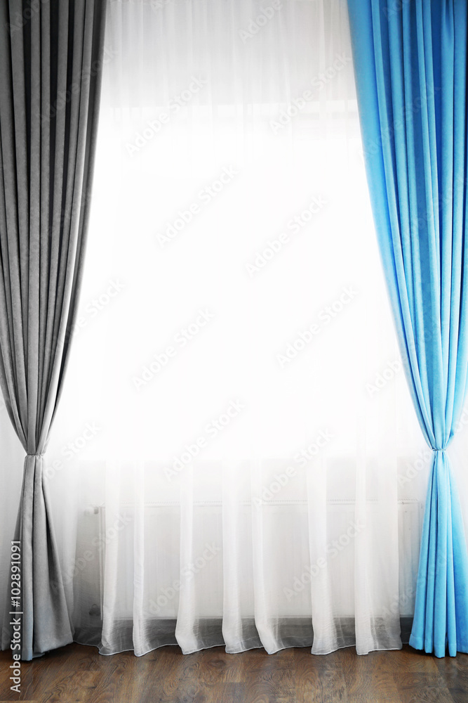 Room window with white, blue and grey curtains