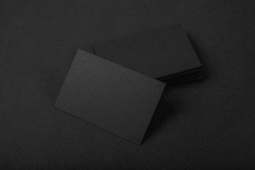 Stack Of blank black business cards on textile background 
