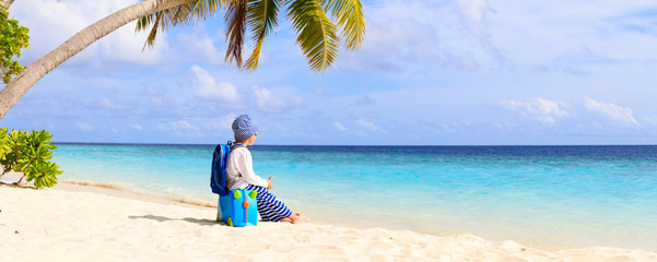 little boy travel on beach with suitcase and toy plane