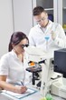 © cirkoglu - Young scientists studying new substance or virus in microscope