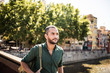 © funkyfrogstock - Handsome bearded man walking on bridge and looking away