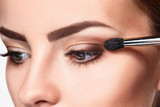Beautiful female eyes with bright blue make-up and brush
