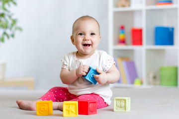 baby toddler playing color toys at home or nursery