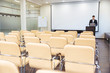 © Drobot Dean - Serious speaker using laptop in empty boardroom