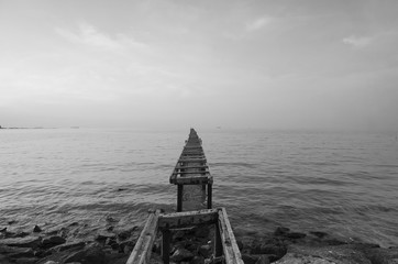 Poster - Broken wood bridge and waves crashing on sea at during sunset