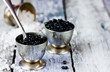 Black caviar in small round metal tin on ice. Selective focus